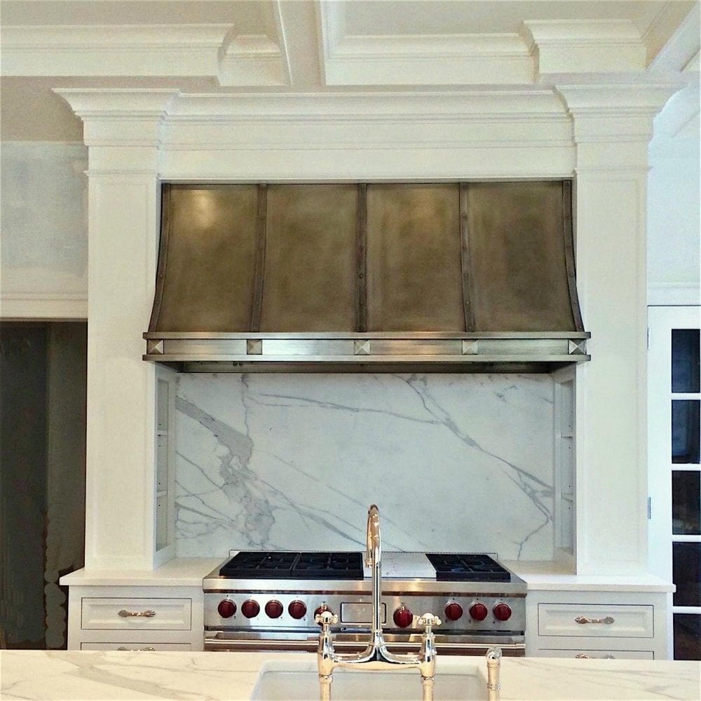 dream kitchen nickel hood white cabinets - wolf range with calacatta gold slab kitchen backsplash. Design and photo by Laurel Bern - Faucet by Perrin and Rowe. Hardware available at myknobs.com - custom cabinetry by Jem Woodworking