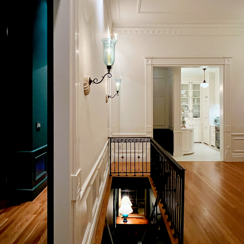 Empty living room - Anglo Indian sconces incandescent light bulbs.