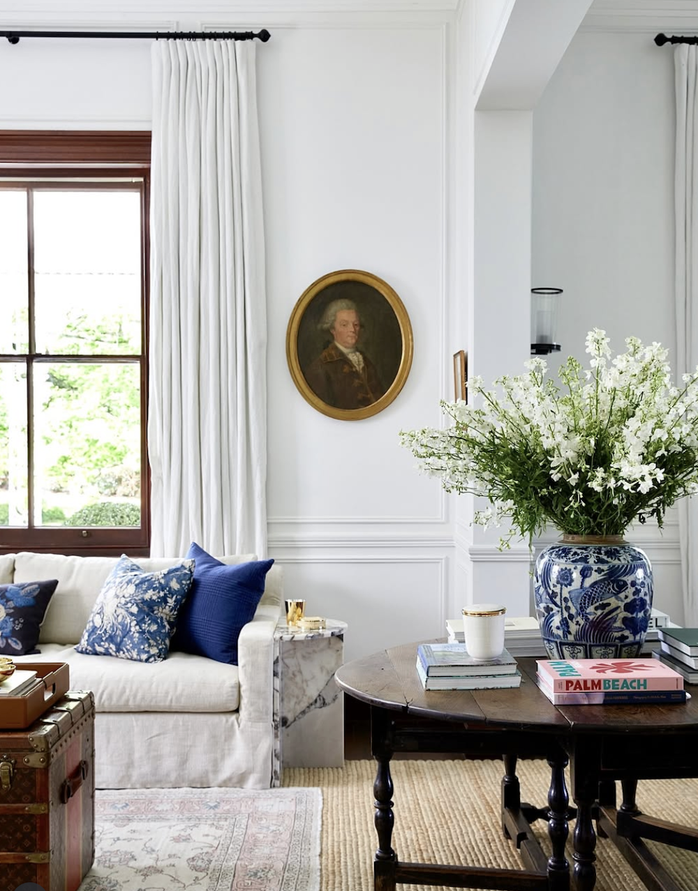 White living room, blue pillows, layered rugs